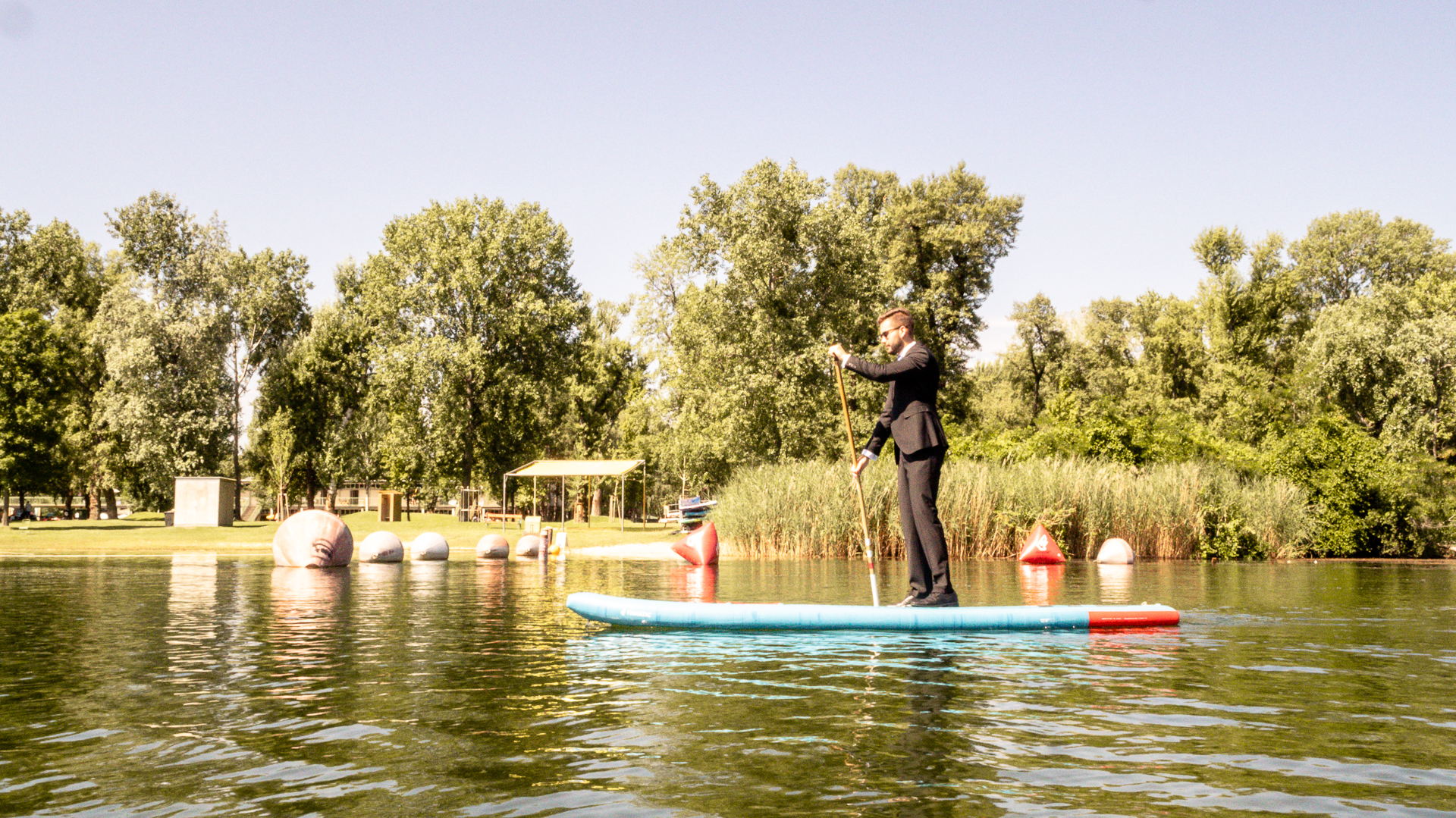 Stand Up Paddler im Anzug auf der Alten Donau
